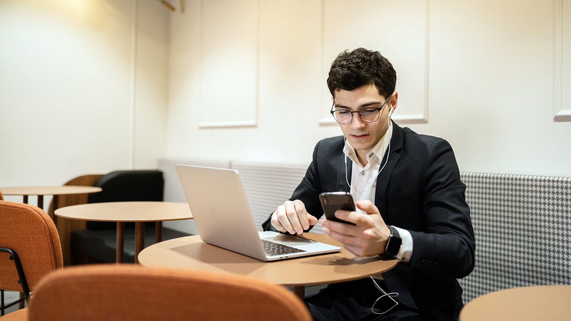 A man in glasses business suit working in the office, writes a message to a partner by e-mail