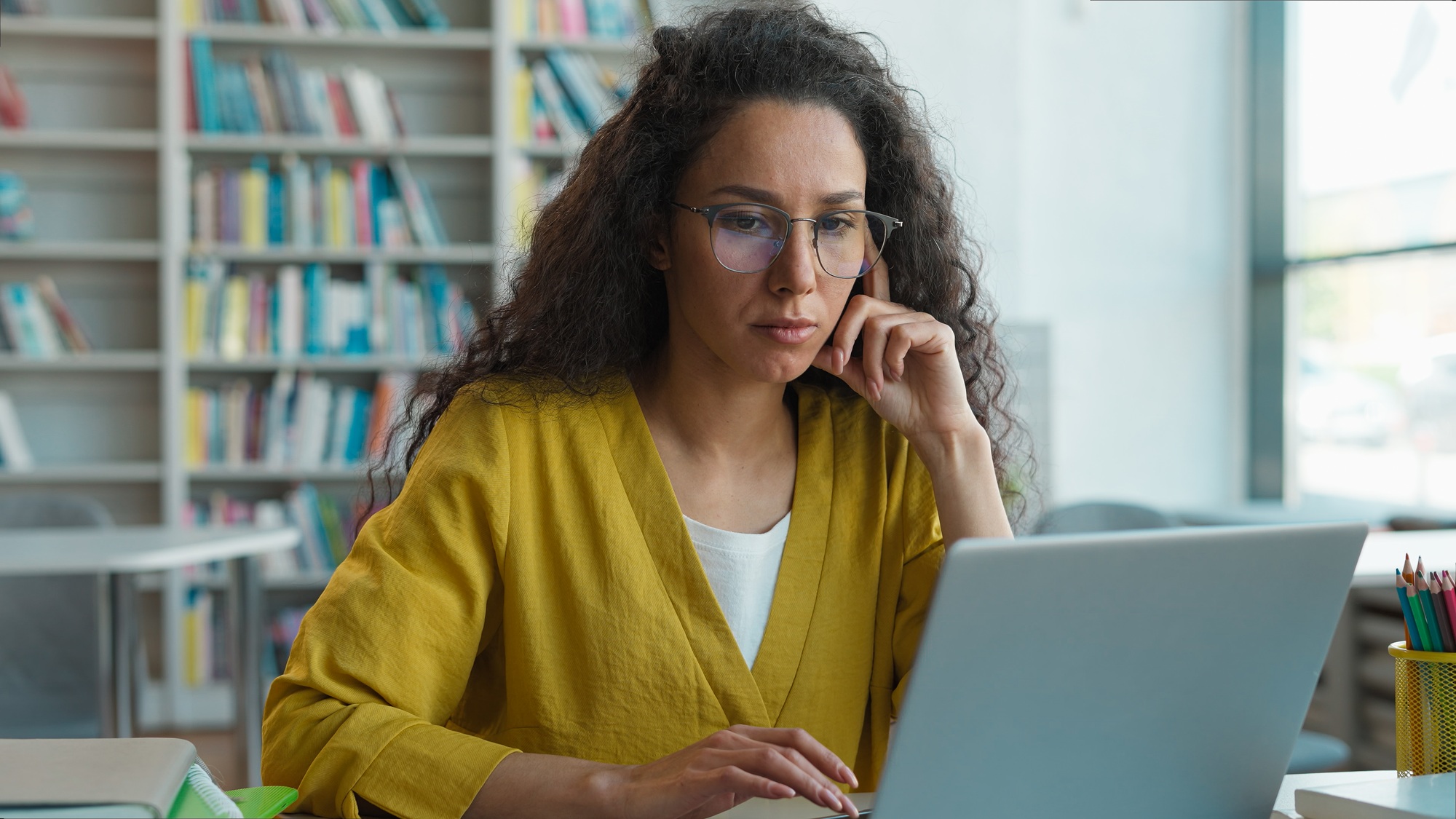Latina Caucasian Hispanic woman working typing laptop desktop computer pc library university
